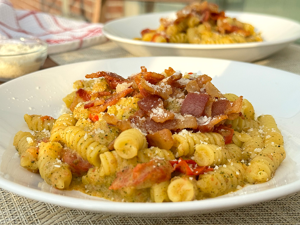 2 bowls of pasta on a table outside