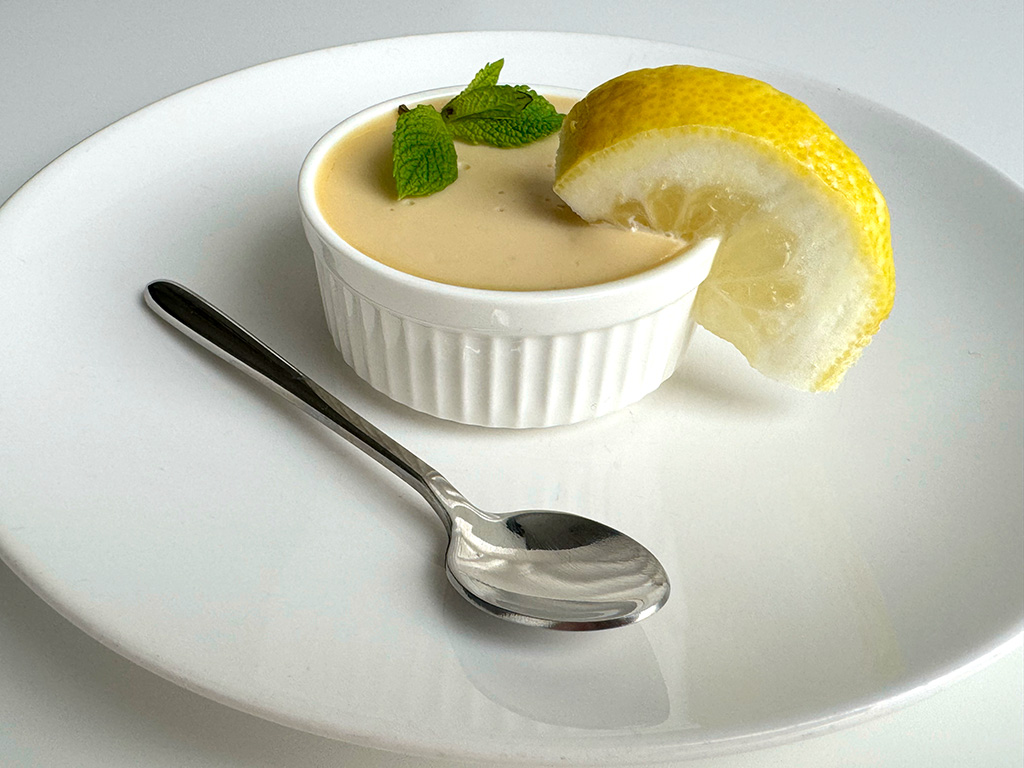 Posset in a ramekin garnished with lemon and mint