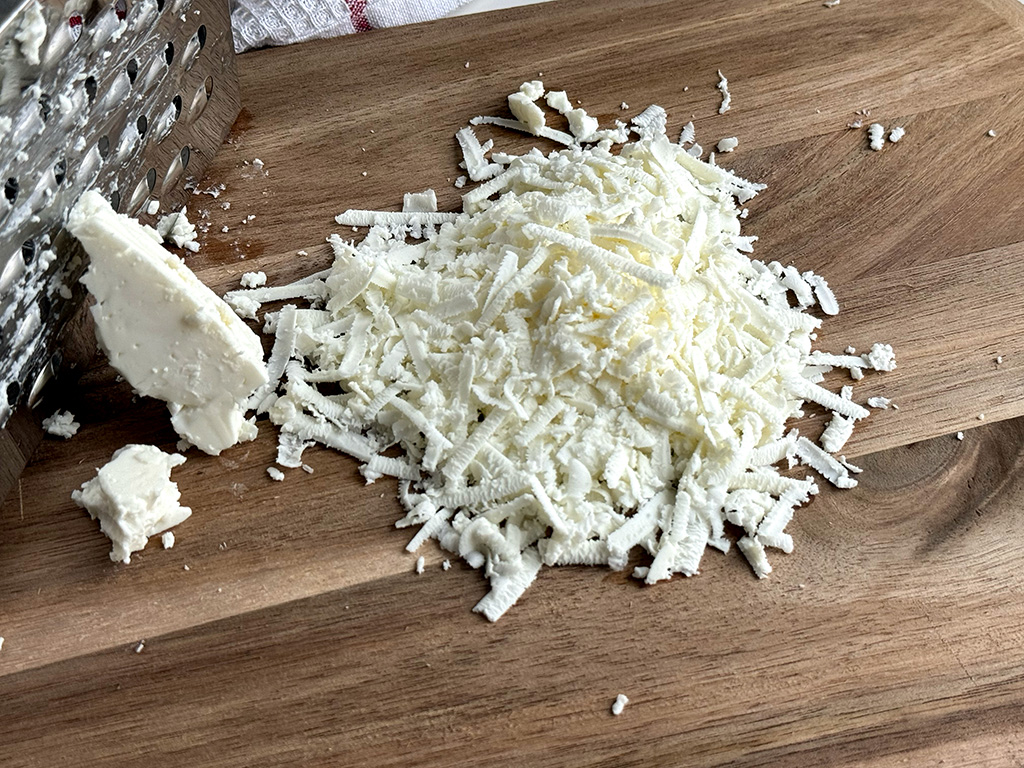 Grated serene cheese on a cutting board